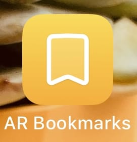 An iOS app icon with a bookmark symbol and orange background